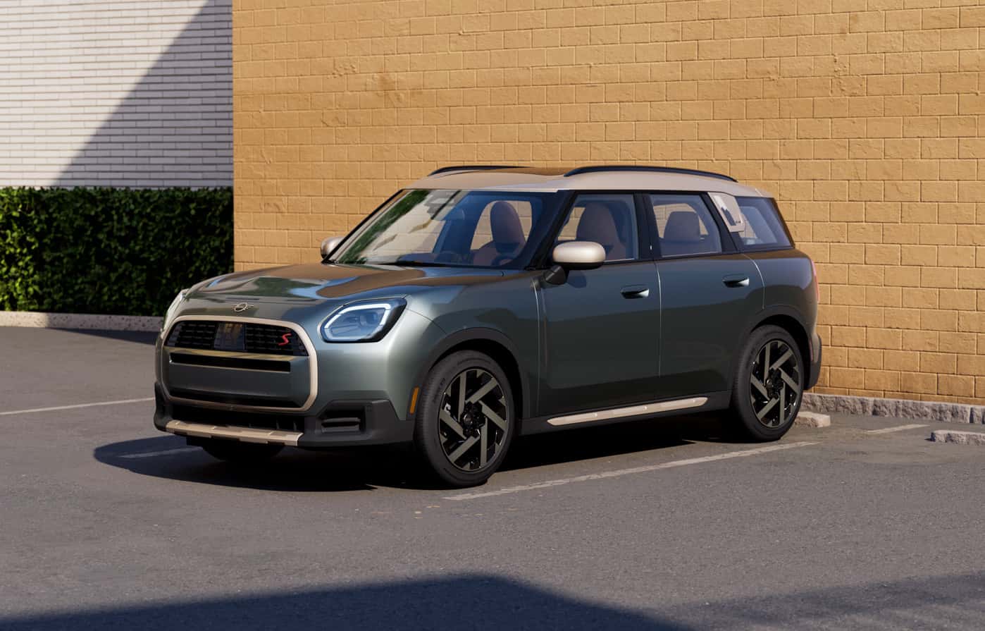 Gray MINI Countryman parked beside a modern brick wall.