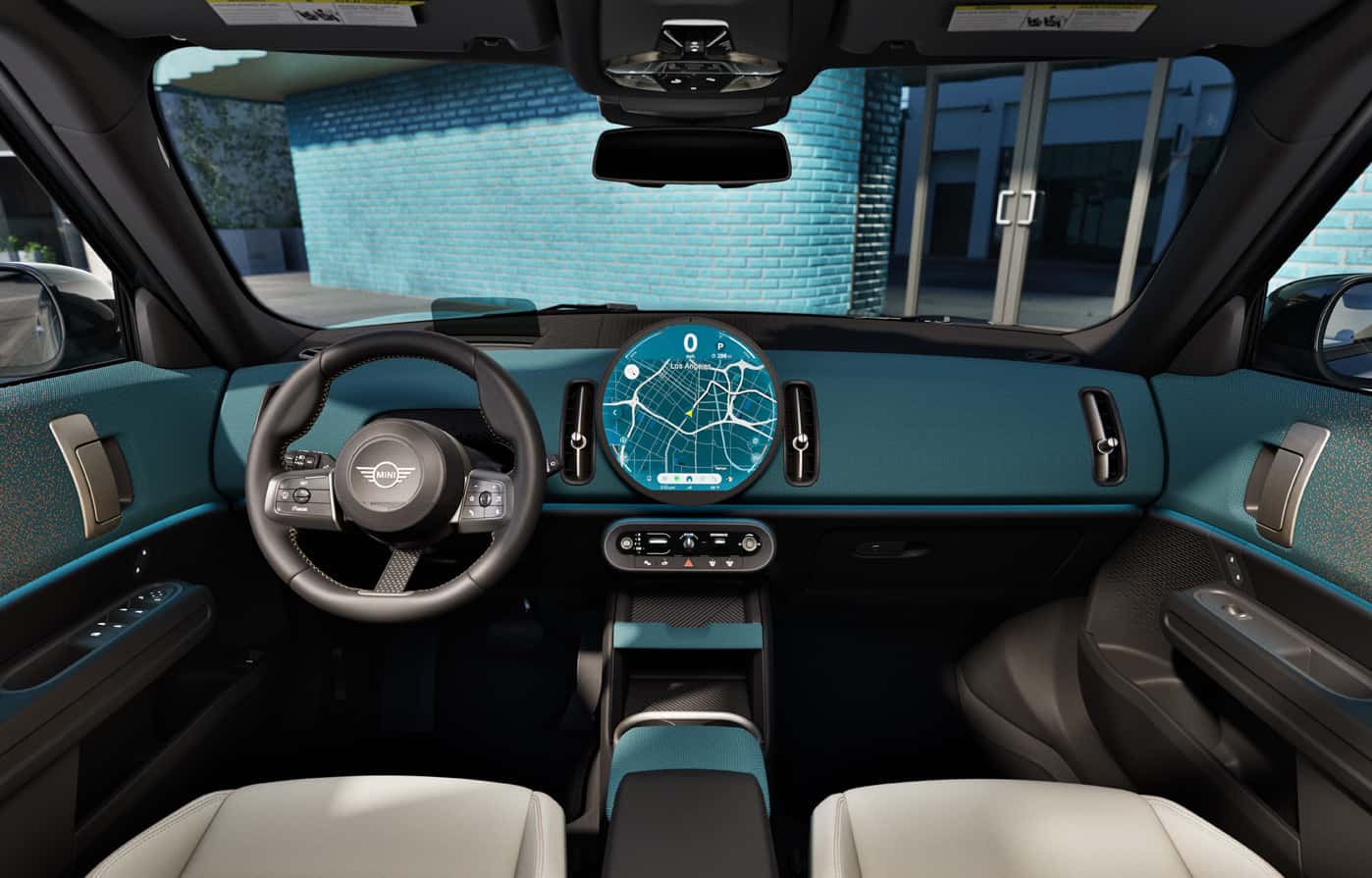 Modern MINI interior with a circular central display showing navigation, surrounded by clean, minimalist controls and a distinctive, driver focused cabin design.