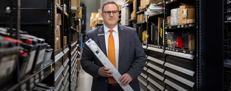 Sewell parts associate carrying a vehicle part to counter.
