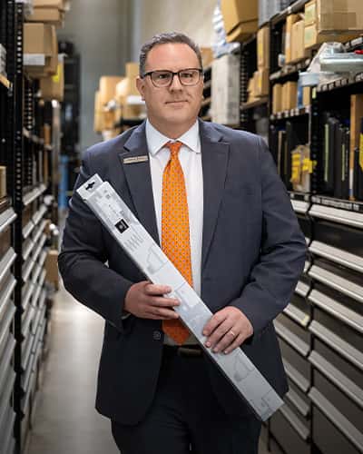 Sewell parts associate carrying a vehicle part to counter.