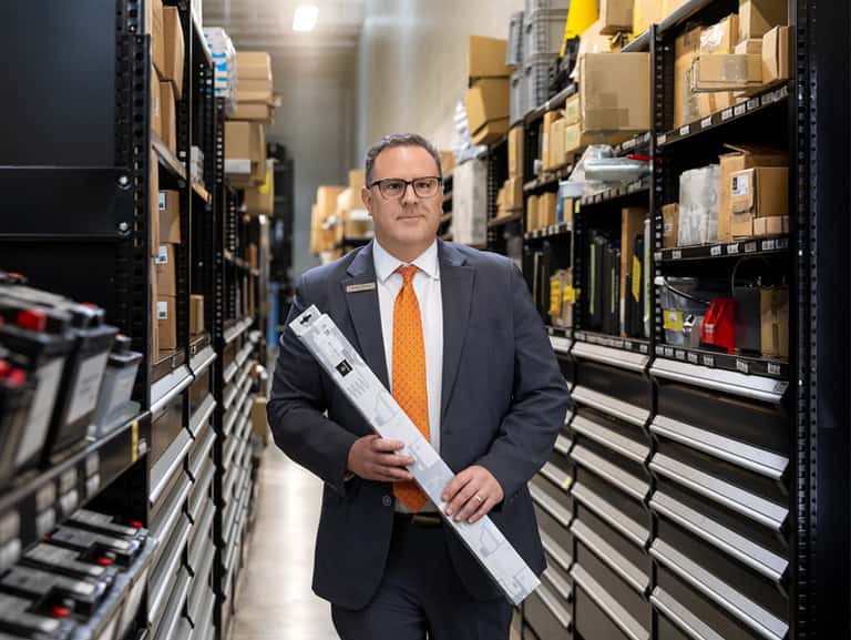 Sewell parts associate carrying a vehicle part to counter.