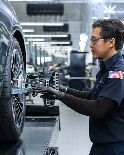 Sewell technician adjusting a customers vehicle tire.