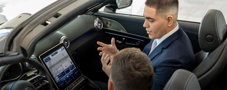 Sewell associate talking through vehicle technology with a customer.