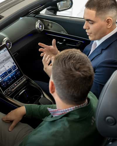 Sewell associate talking through vehicle technology with a customer.