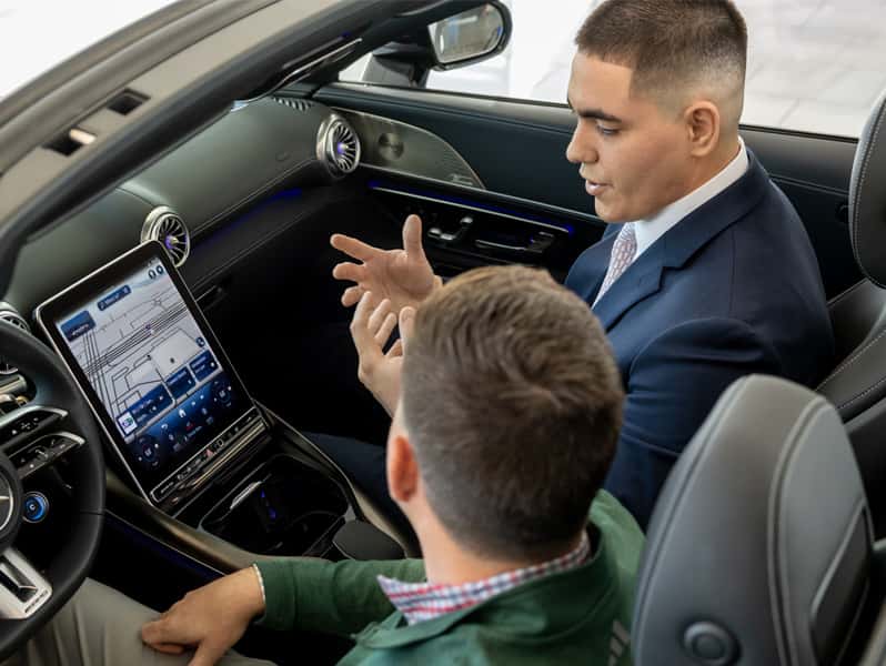 Sewell product specialist explaining vehicle features to a customer.