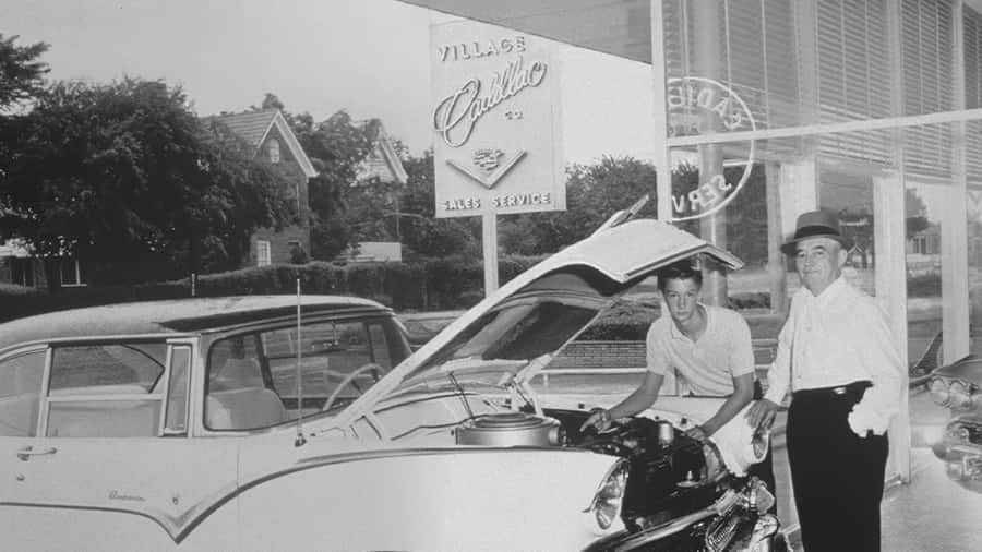 Carl Sewell Sr. and Mr. Sewell working on a Cadillac.