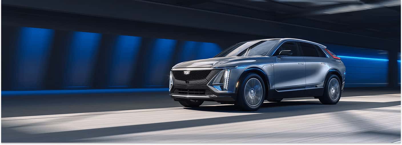 Front three-quarter view of a silver 2026 Cadillac LYRIQ driving through a tunnel.