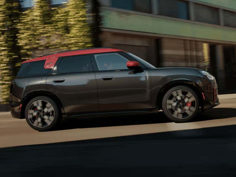 MINI John Cooper Works Countryman ALL4 driving in urban setting highlighting performance styling and red roof accents