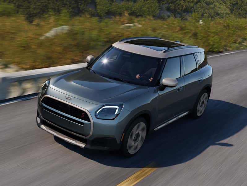 MINI Countryman S ALL4 driving on open road with signature MINI design and all wheel drive capability.