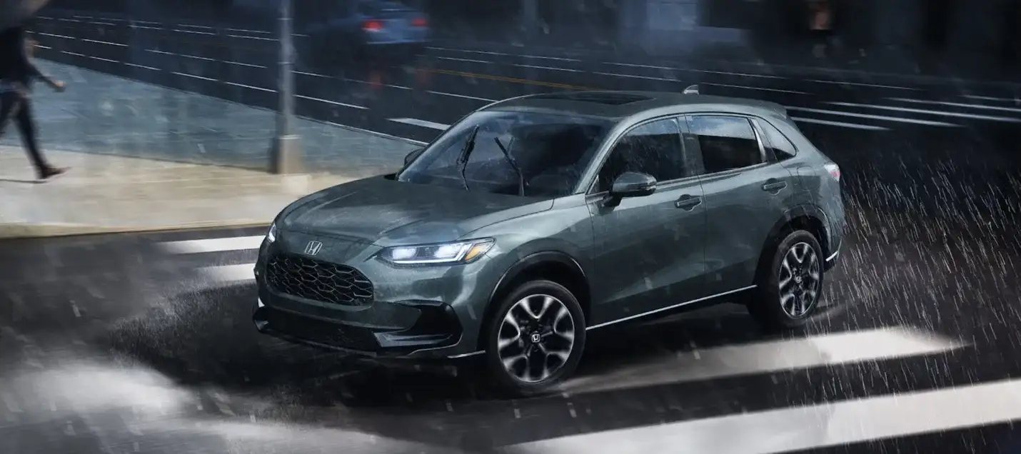 The 2026 HR-V driving through rain on a city street