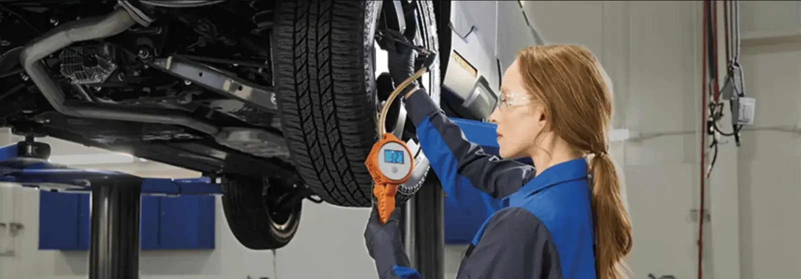 Factory-trained Subaru technician inspecting a vehicle’s undercarriage with specialized diagnostic tools