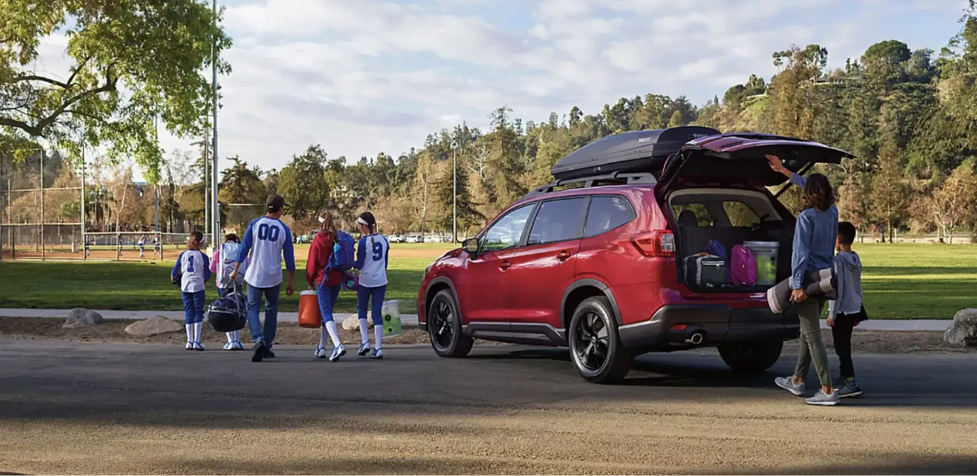 The 2026 Subaru Ascent parked at a park with its rear hatch open and cargo area packed with sports gear