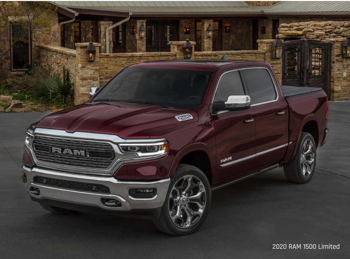 Three-quarter view of a Ram 1500 Limited in Red parked on a driveway outside a stone lodge.