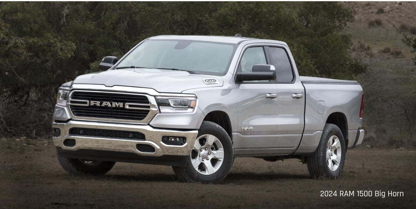 Three-quarter front view of a Ram 1500 Big Horn in Silver parked on a dirt field.