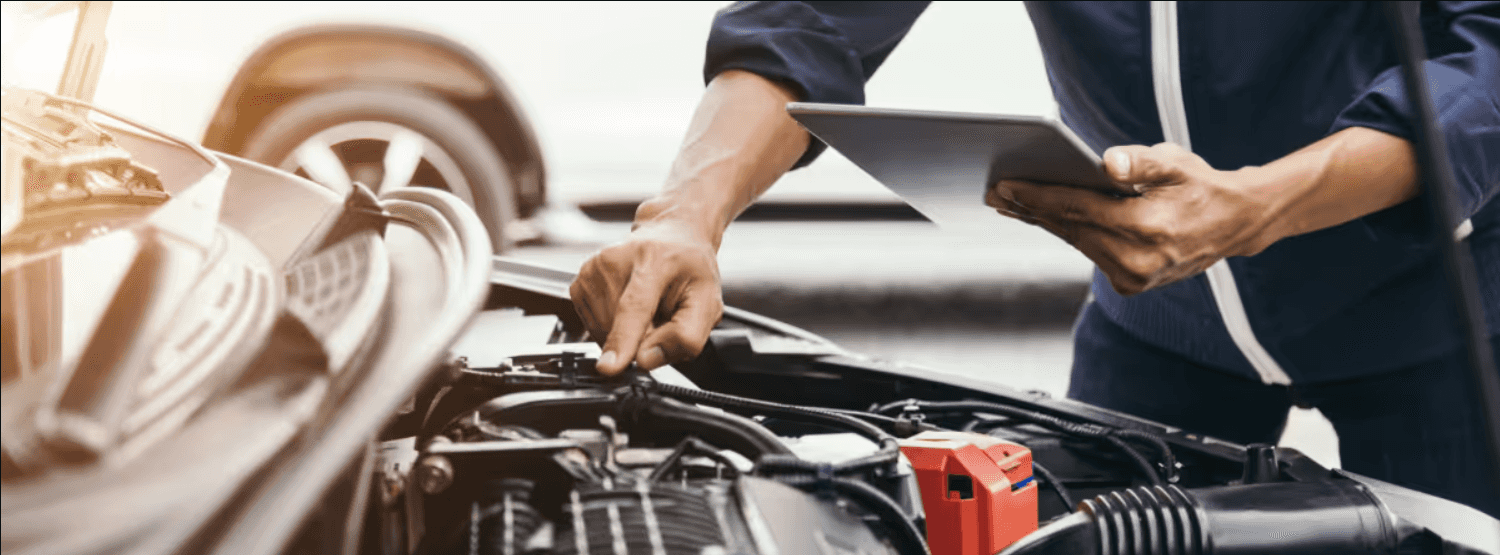 a mechanic works on the engine of a car