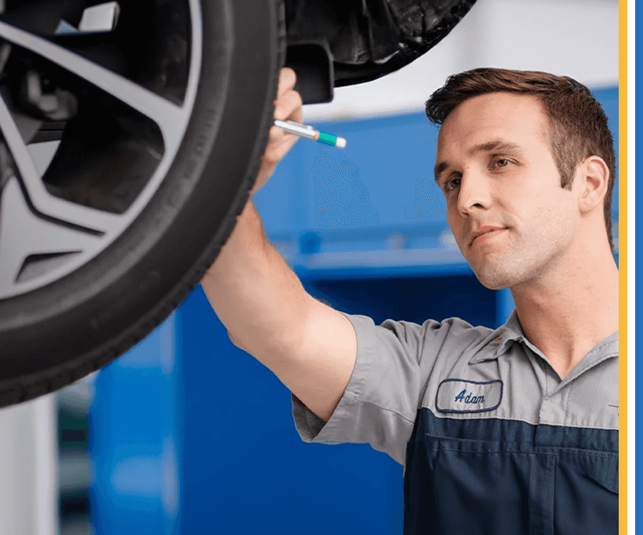Service tech looking at car