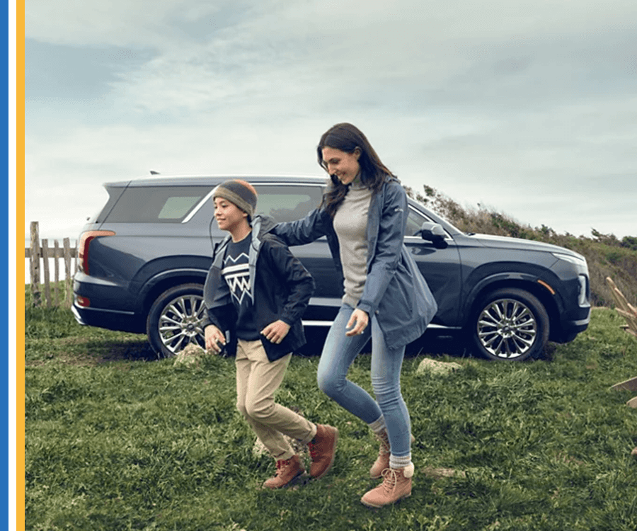 Woman walking with son in front of car
