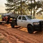 2026 Ram 2500 heavy-duty truck hitched to a farm equipment trailer on a rural east Alabama road near Lee County