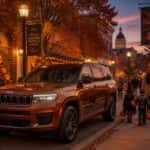 Jeep Grand Cherokee L parked on a festive Halloween-decorated downtown Prattville street at dusk with glowing pumpkins and families in costume