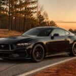 2026 Ford Mustang fastback on a central Alabama road at dusk, Shadow Black exterior