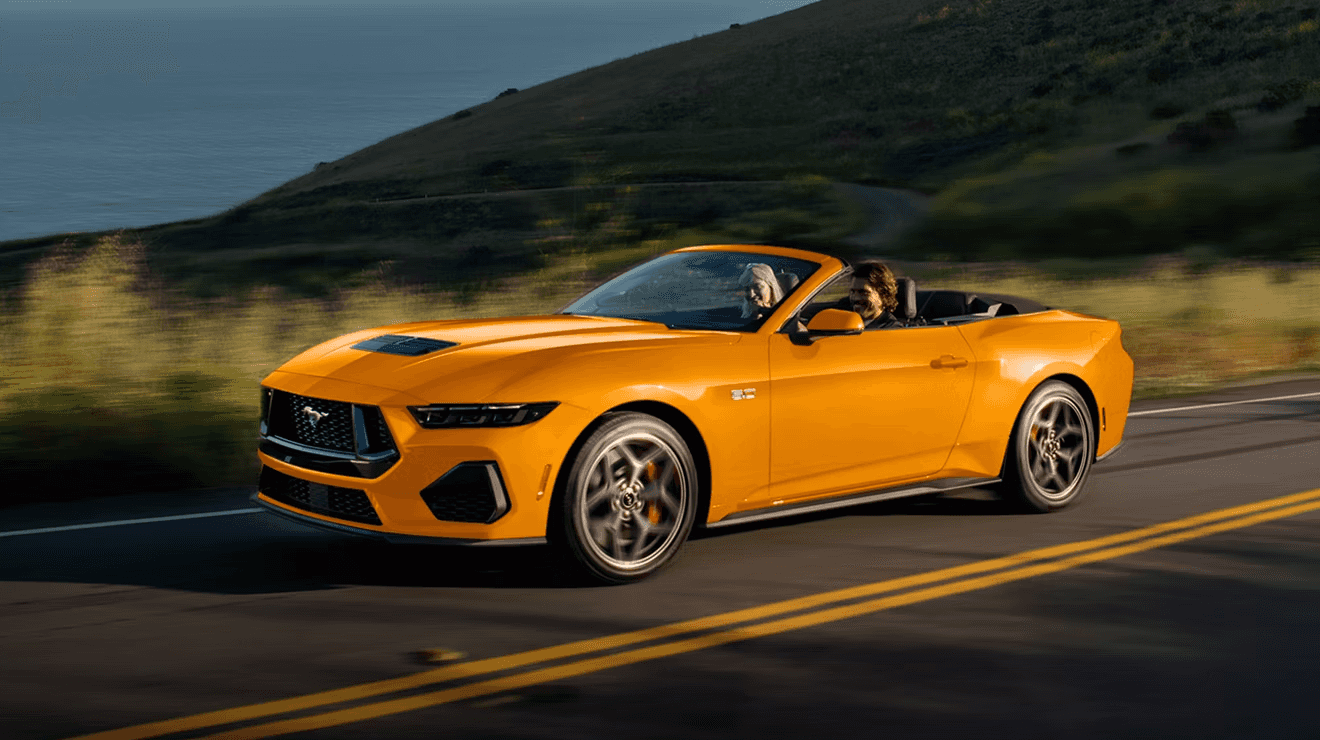 Yellow Orange 2026 Ford Mustang Driving along the cliffs looking over the ocean.