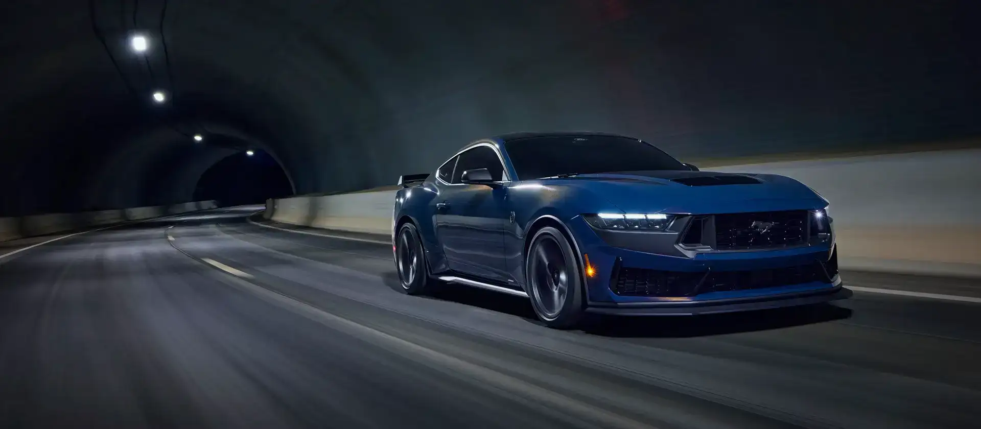 Blue 2026 Dark Horse Mustang driving through a tunnel
