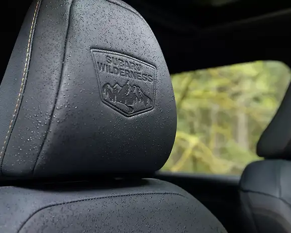 Close-up of a Forester Wilderness front headrest with the embossed Subaru Wilderness logo on StarTex upholstery