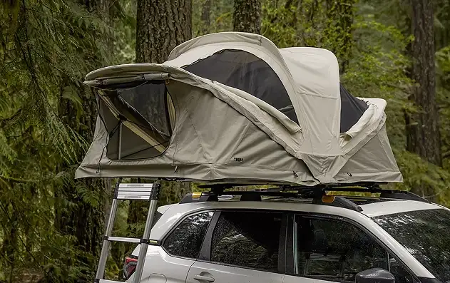 2026 Subaru Forester with a rooftop tent set up at a forest campsite