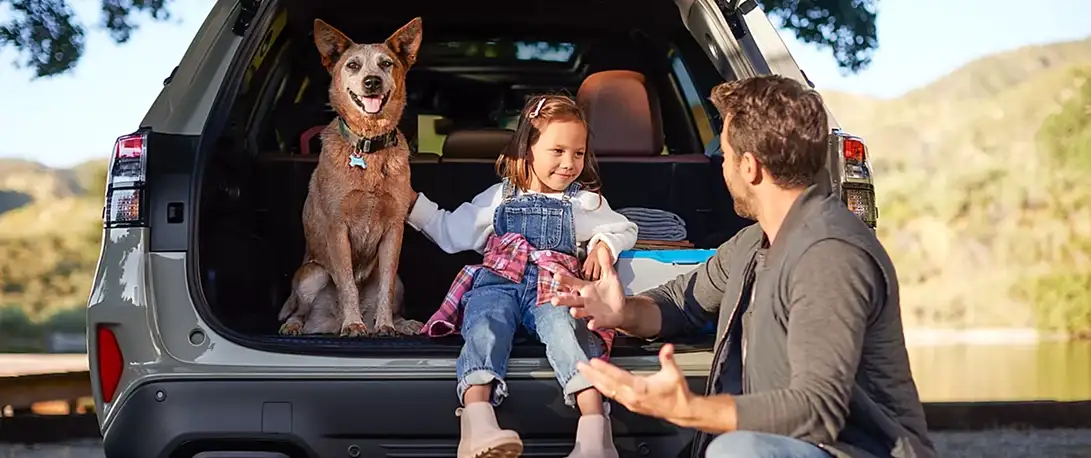 Family and a dog gathered at the open rear gate of a 2026 Subaru Forester