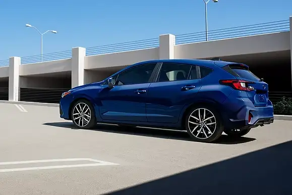 Blue 2026 Subaru Impreza parked by a concrete parking structure