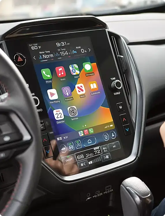 2026 Subaru Impreza touchscreen with a driver holding a phone showing Apple CarPlay