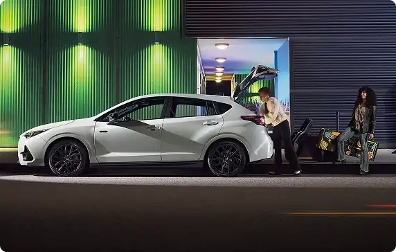 White 2026 Subaru Impreza parked at night while people load gear