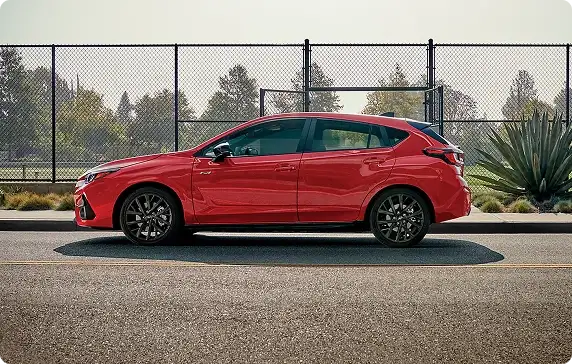 Side profile of a red 2026 Subaru Impreza parked on a street