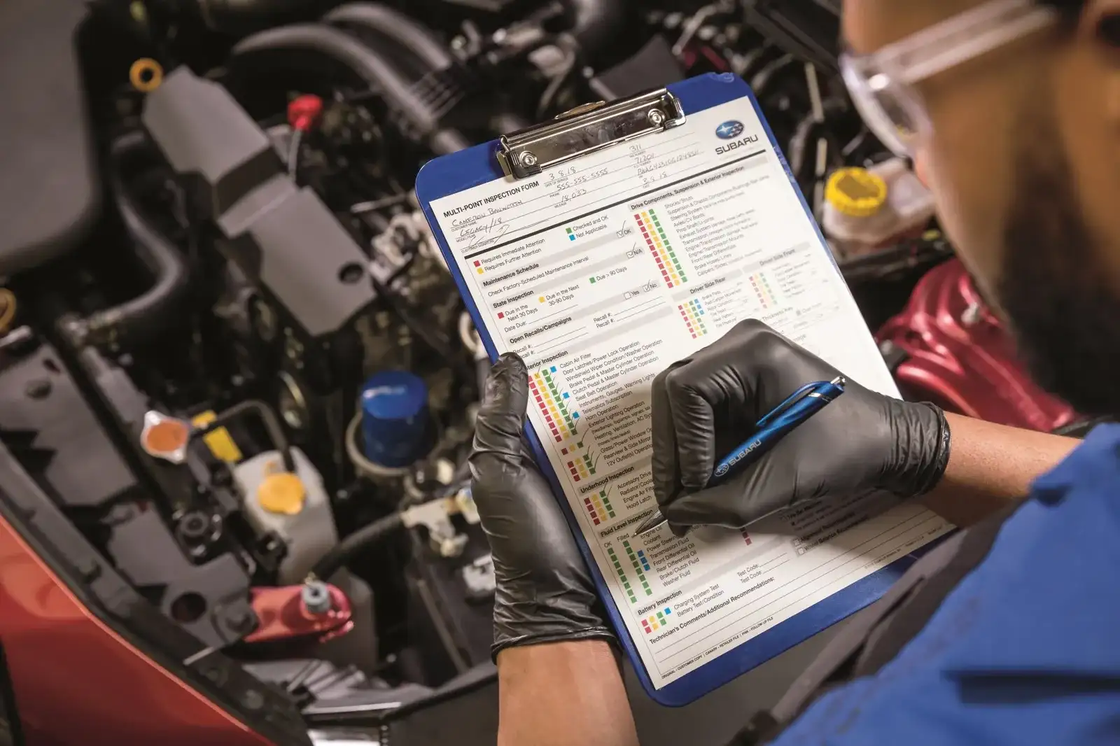 A Findlay Subaru of Las Vegas service technician completing a multi-point inspection on a Subaru in the service bay