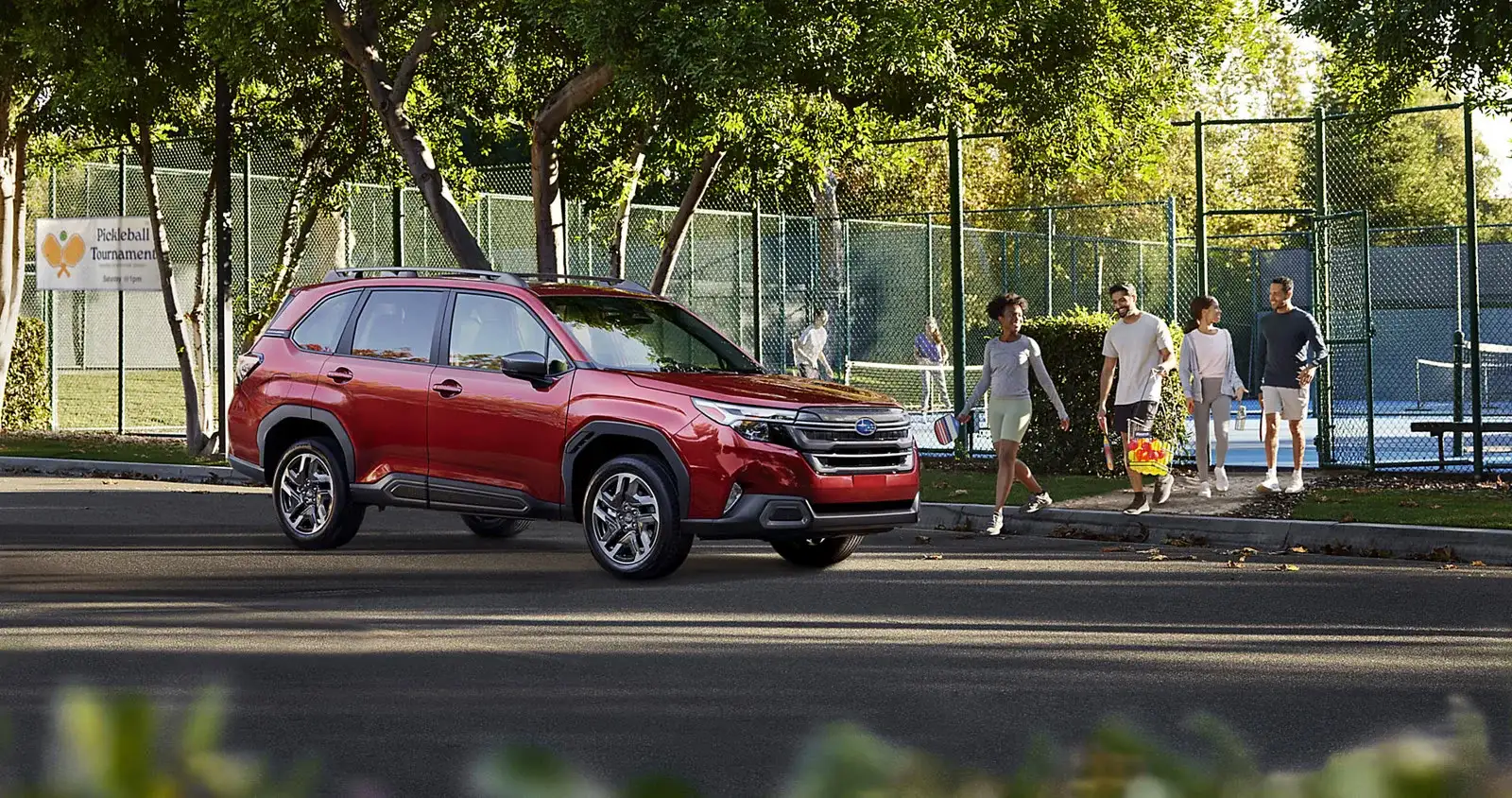 A 2026 Subaru Forester parked at the courts as a family walks up after a weekend game