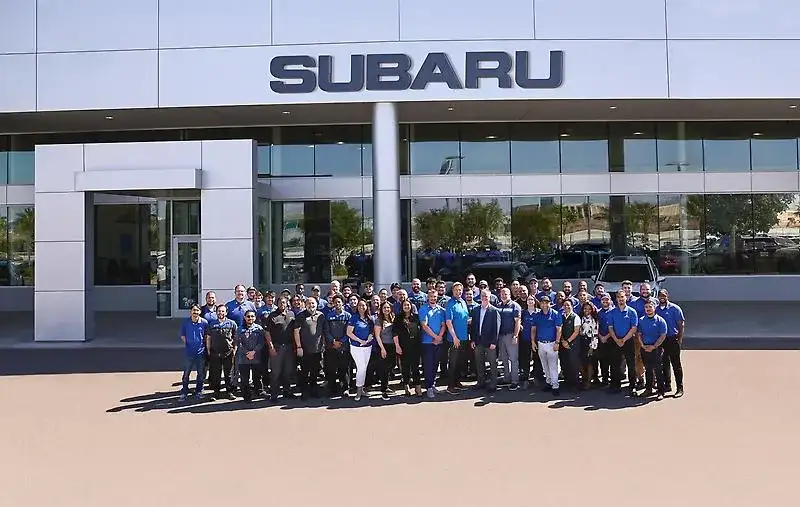 The Findlay Subaru of Las Vegas team gathered in front of the dealership entrance under the Subaru sign at 6455 Roy Horn Way.