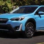 Blue 2023 Subaru Crosstrek Hybrid on a City Street