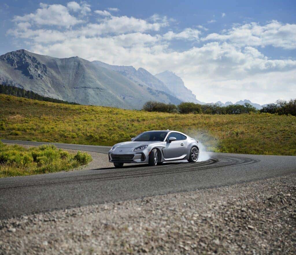 2023 Subaru BRZ drifting on a rural mountain road.