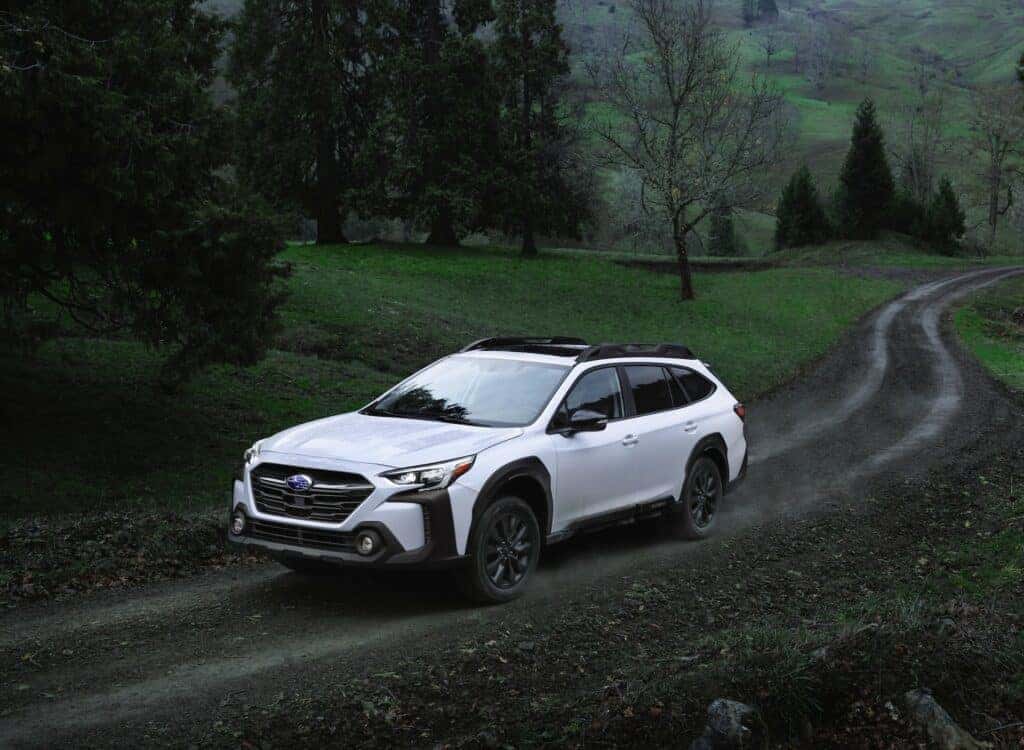 2023 Subaru Outback traveling down a dirt road to a mountain trail