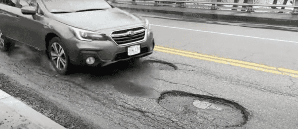 Subaru Driving on a street with potholes.