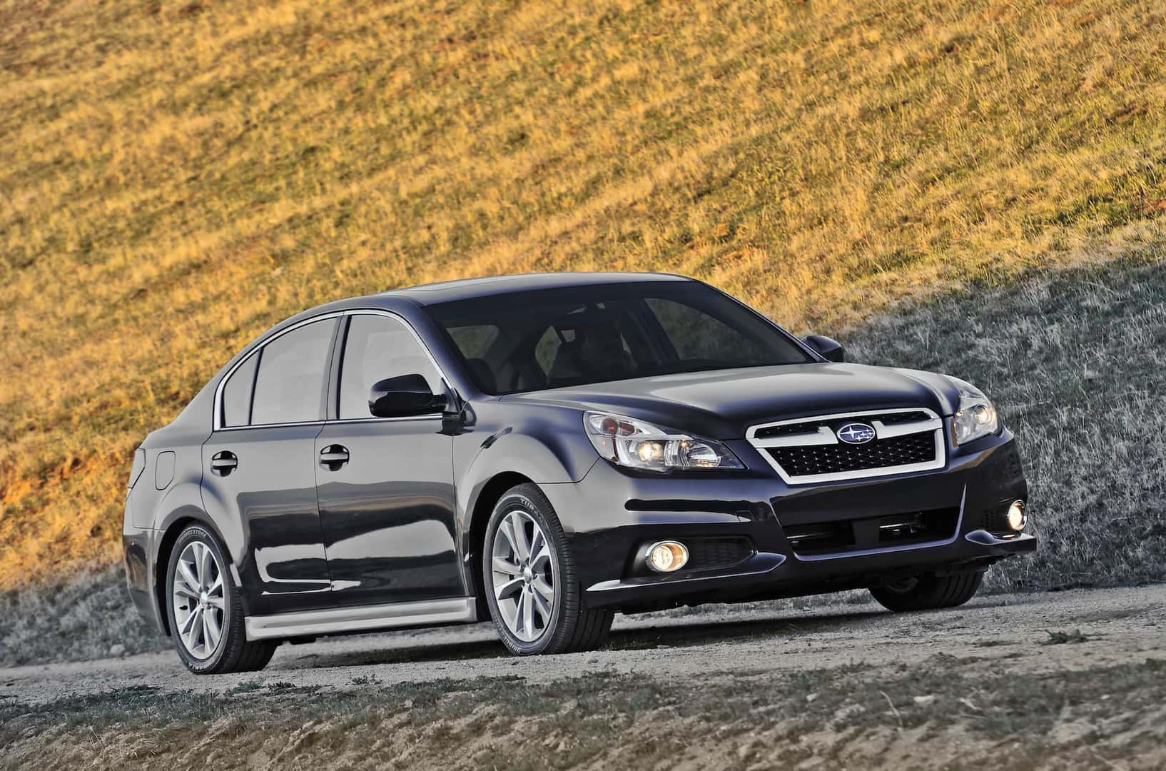 2012 Subaru Legacy in black parked on a rural road.
