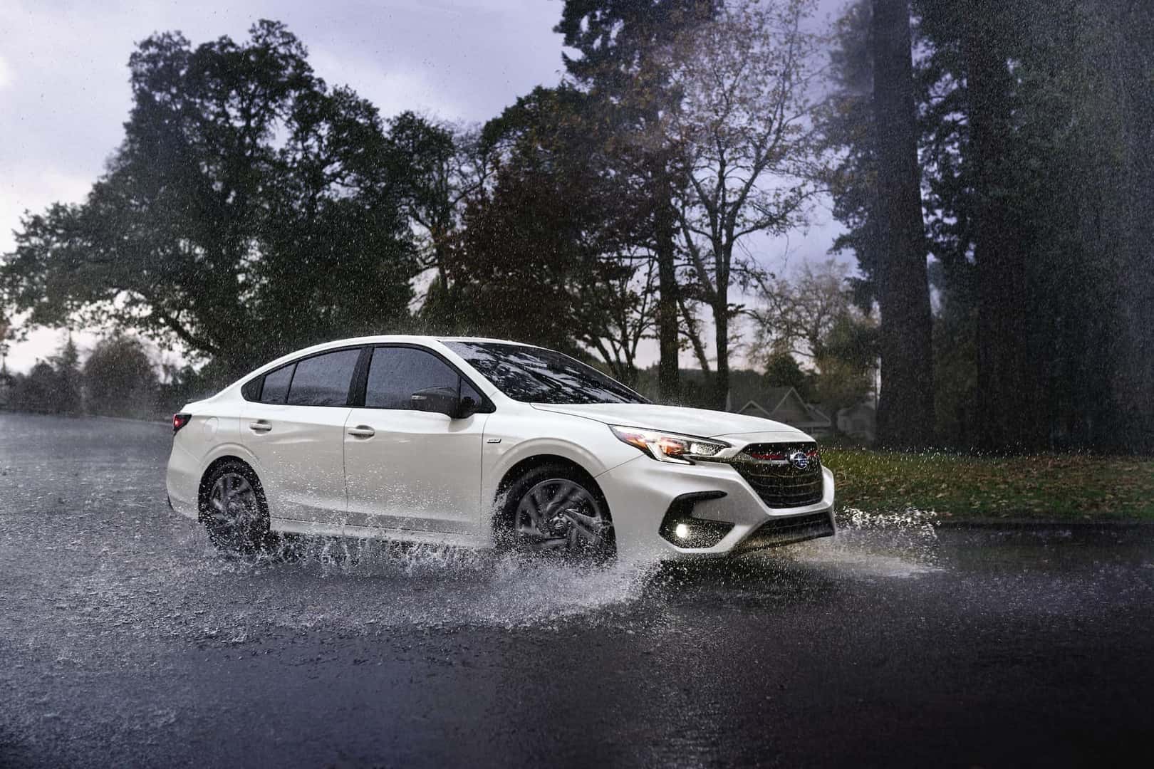 2023 Subaru Legacy in white driving through rainy weather. 