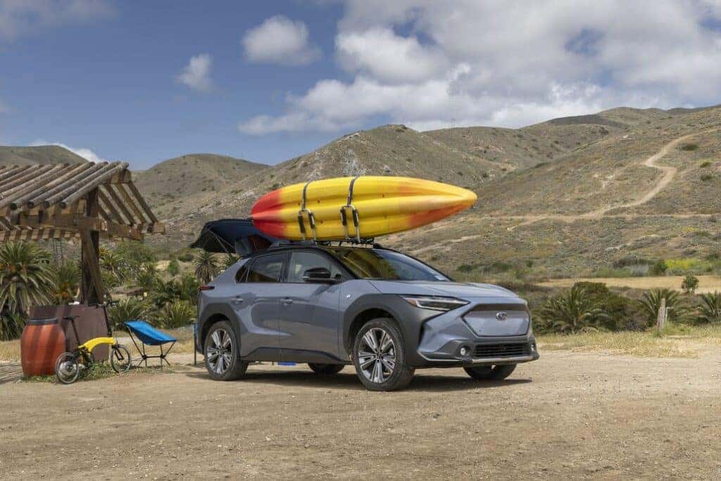 Subaru Solterra with a Kayak on its Roof Rack Parked Front 3/4 View in a Desert