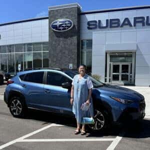 Mary, from Kimbelry, Idaho, with her Horizon Blue Pearl 2024 Subaru Crosstrek Premium in front of Twin Falls Subaru