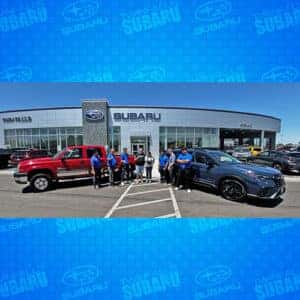 Alexa with her 2 new cars, a 2003 Chevy Silverado 2500HD & a Cosmic Blue Pearl 2024 Subaru Ascent Onyx Edition in front of Twin Falls Subaru