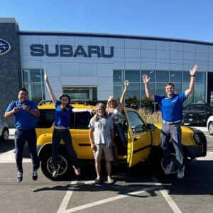 Mark & His wife, from Hagerman Idaho, with their Solar Yellow 2003 Nissan Xterra SE, with Purchase Advisor Kaden Barrus in front of Twin Falls Subaru