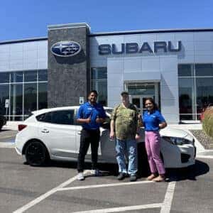 Chuck, from Jerome, Idaho, with his Crystal White Pearl 2018 Subaru Impreza 2.0i hatchback in front of the Magic Valley's #1 Volume Automotive Retailer - Twin Falls Subaru with Purchase Advisor Lizet Ramos.
