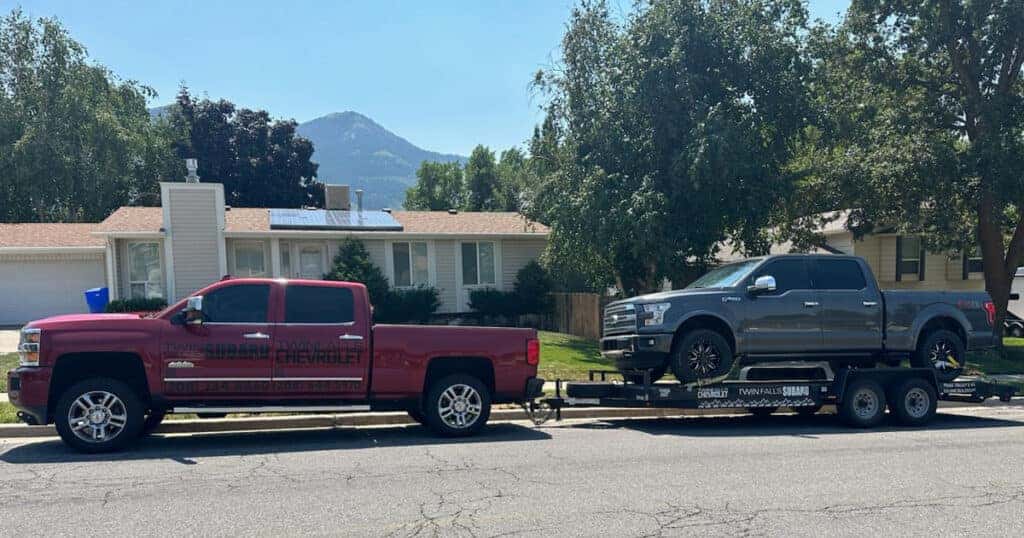 Twin Falls Subaru's Vehicle Acquisition Specialist Riley Fraser with a Ford F-150 loaded on a trailer in Utah, ready to bring a purchased truck back to Twin Falls, Idaho.