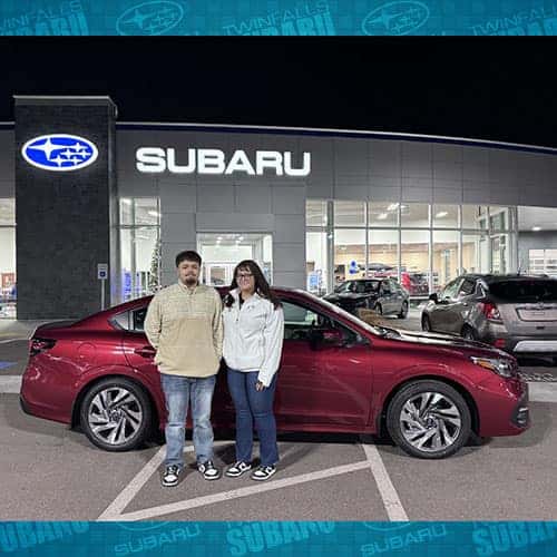 Nadia, from Western Nevada, with her Crimson Red Pearl 2025 Subaru Legacy Limited outside of Twin Falls Subaru, assisted by Purchase Advisor Paola Orozco in Twin Falls, Idaho