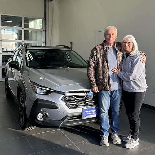 Wanda & Larry from Spring Creek, Nevada with their brand-new Ice Silver Metallic 2025 Subaru Crosstrek Limited in the delivery bay at Twin Falls Subaru